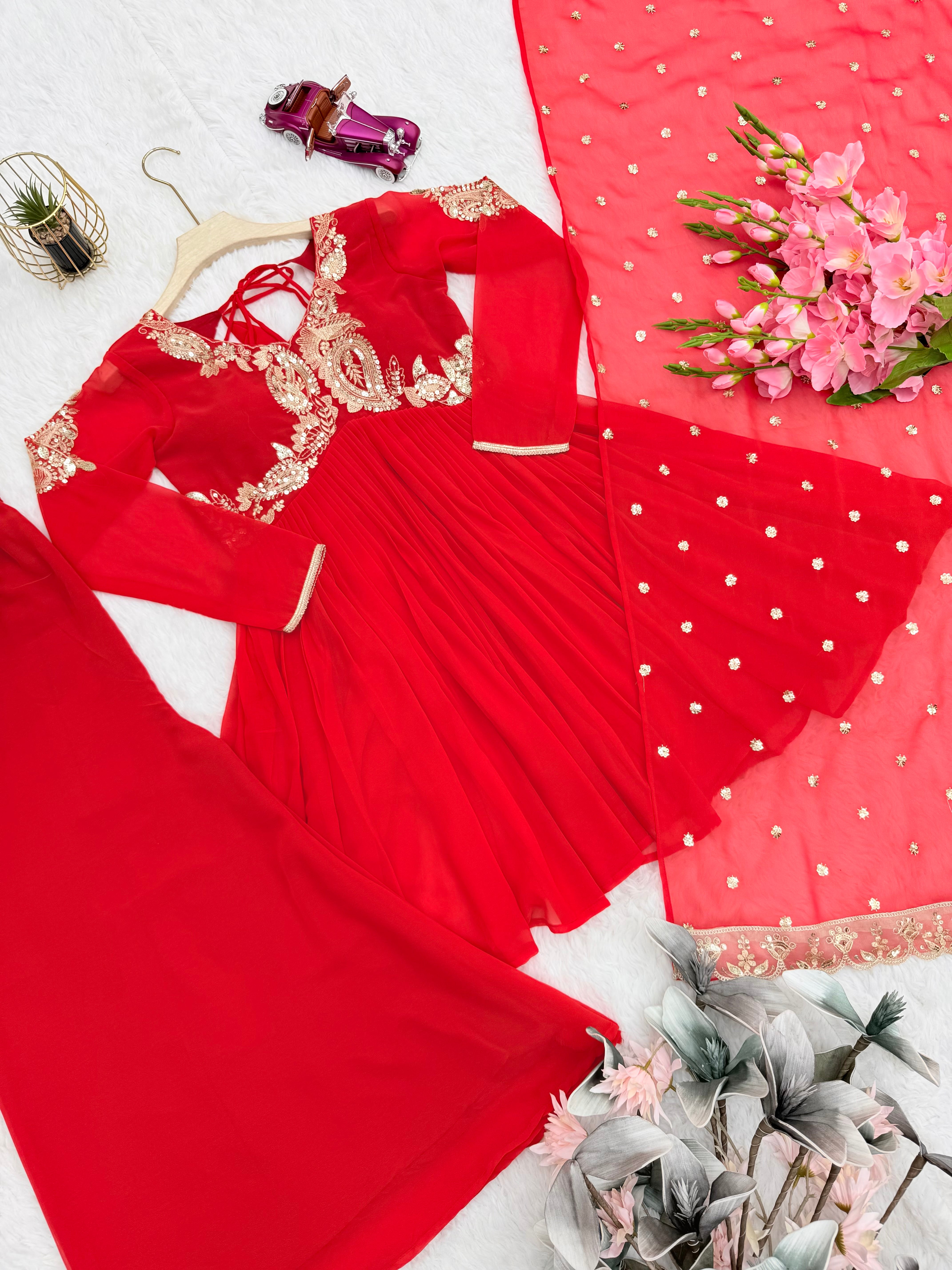 Designer Traditional Red Anarkali Floor-Length Gown with Heavy Golden Zari Embroidery on Bodice and Sleeves, Paired with Golden Beaded Potli Bag and Statement Jewelry – Ideal for Wedding, Festive, or Party Wear