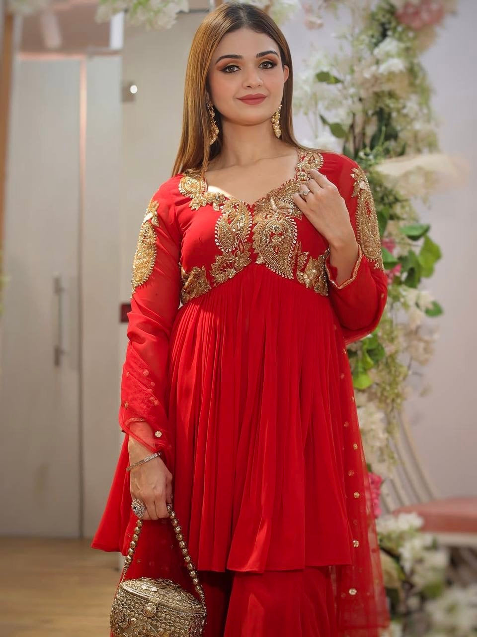 Designer Traditional Red Anarkali Floor-Length Gown with Heavy Golden Zari Embroidery on Bodice and Sleeves, Paired with Golden Beaded Potli Bag and Statement Jewelry – Ideal for Wedding, Festive, or Party Wear