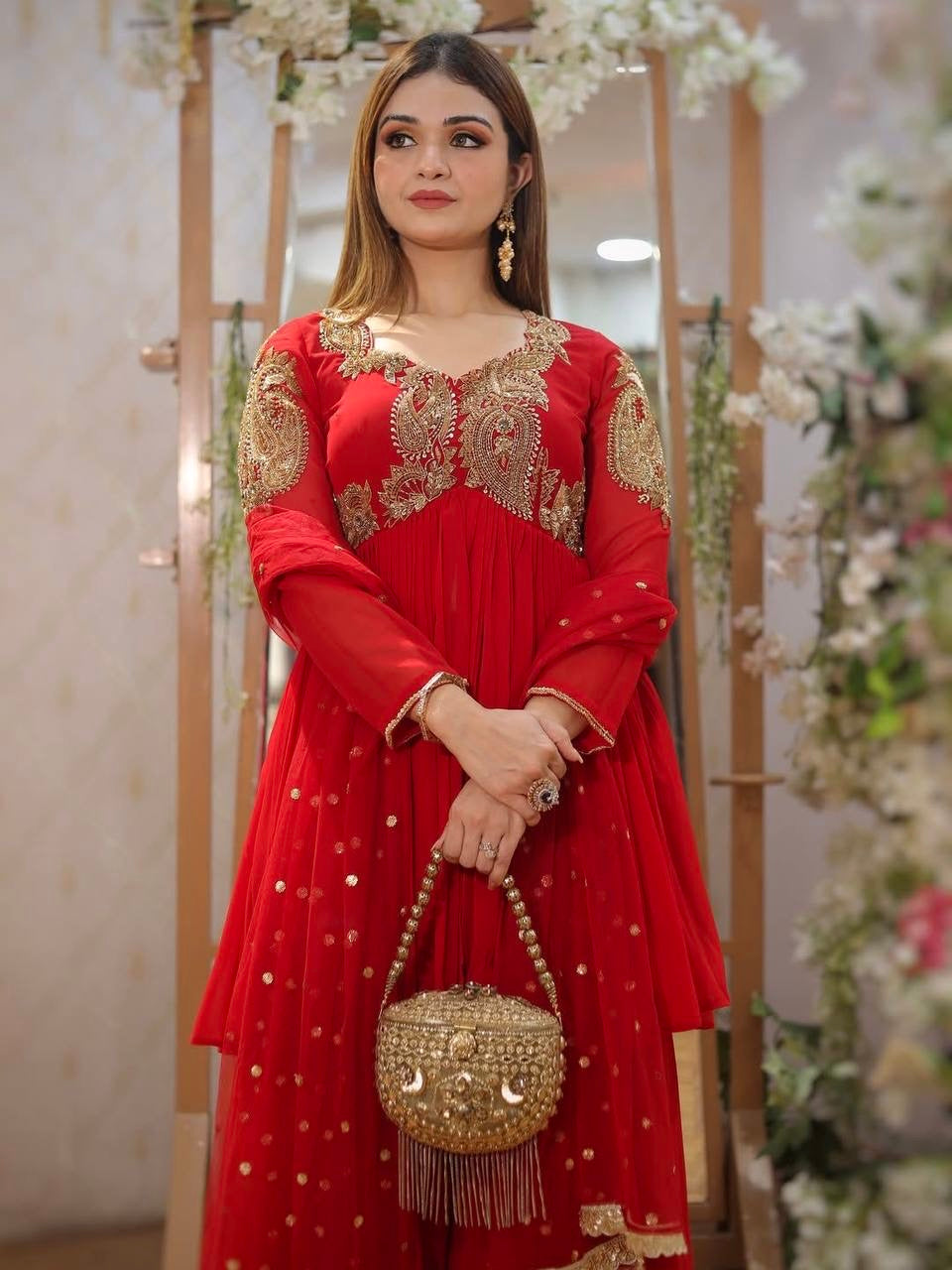 Designer Traditional Red Anarkali Floor-Length Gown with Heavy Golden Zari Embroidery on Bodice and Sleeves, Paired with Golden Beaded Potli Bag and Statement Jewelry – Ideal for Wedding, Festive, or Party Wear